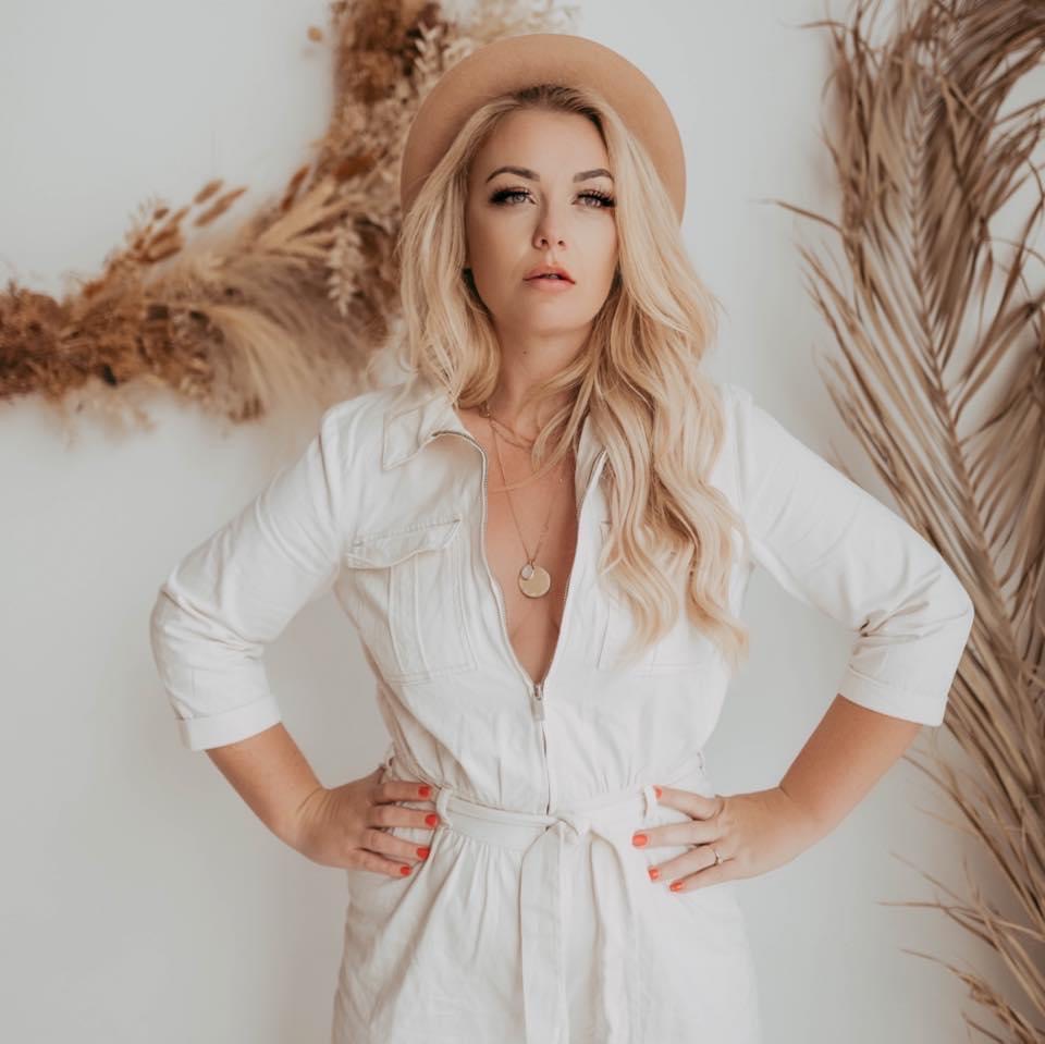 Holly-The Body Positve Mum standing confidently in a neutral studio wearing a white dress and hat — empowerment photography session celebrating body confidence and transformation.